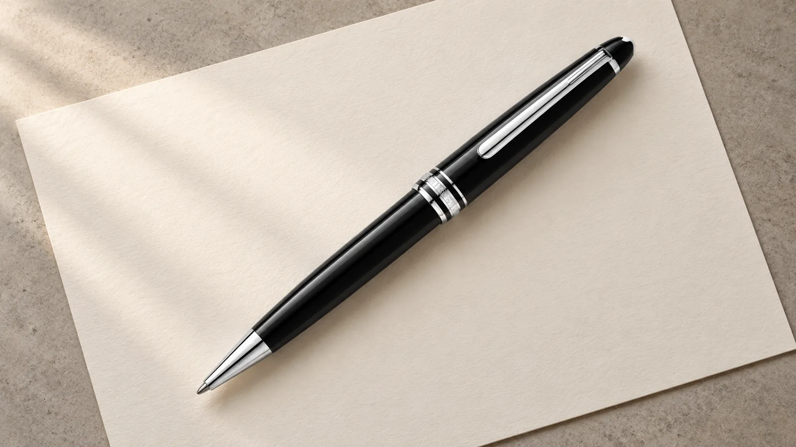 Penna a sfera Montblanc Meisterstück nera su un foglio color avorio.